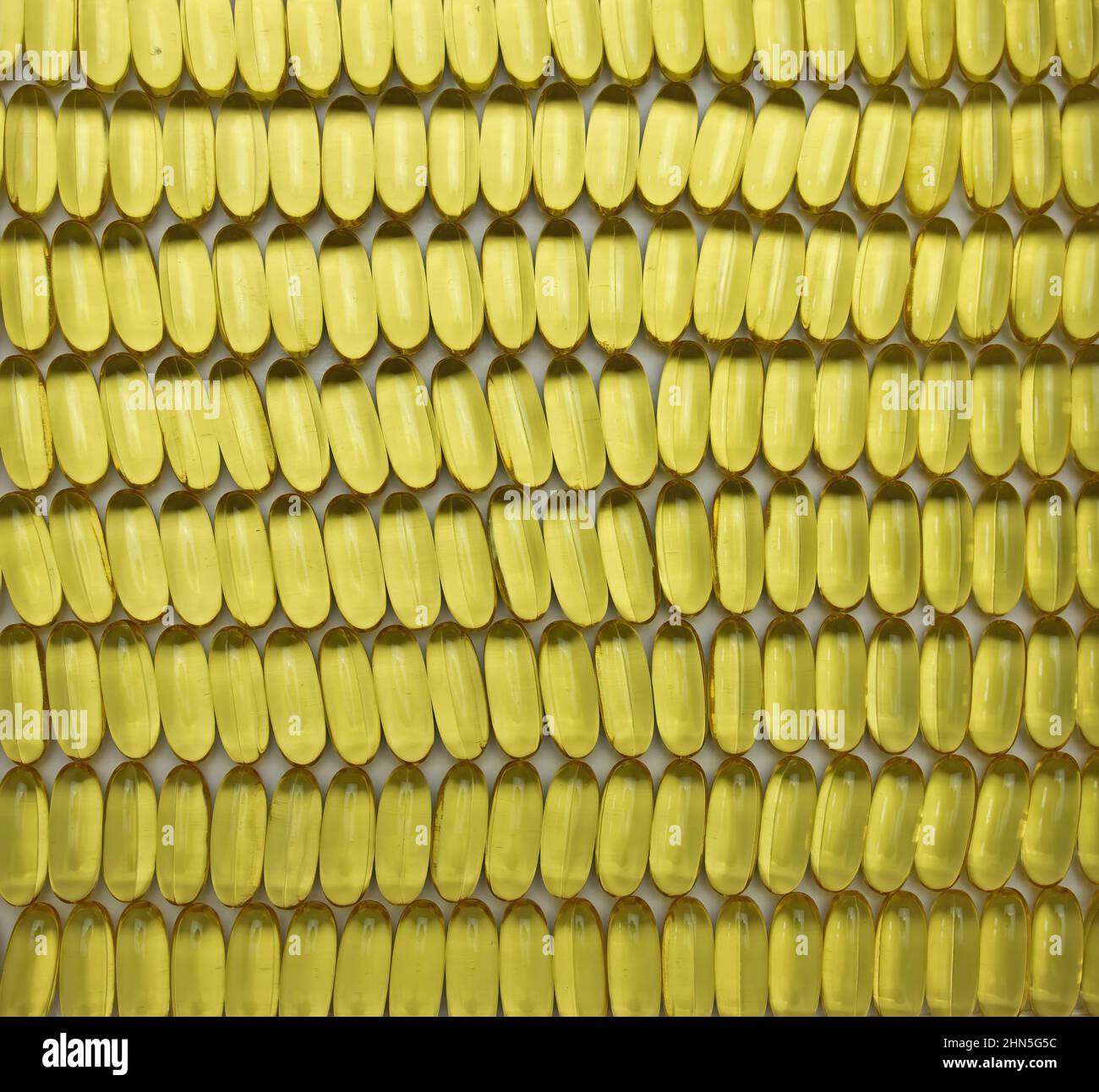 lots of yellow omega 3 oil pills lined up in rows and columns, healthy ...