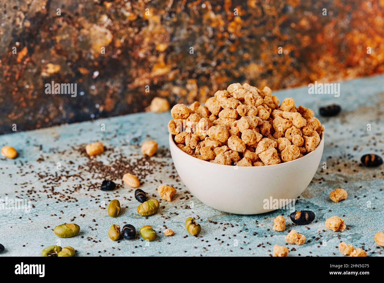 a bowl with some chunks of textured soy protein on a blue rustic wooden table Stock Photo