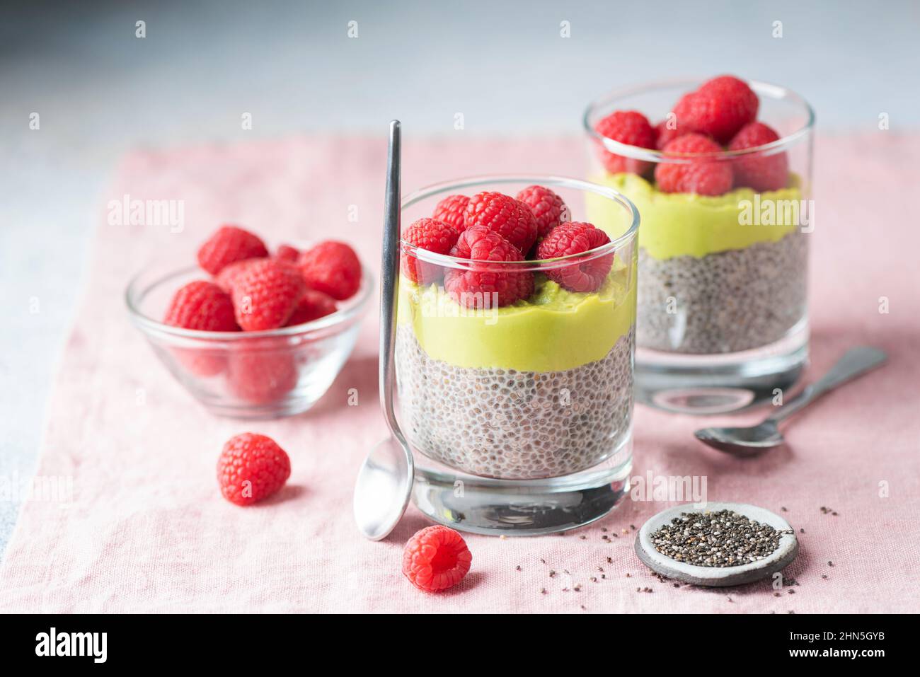 Chia pudding with avocado and raspberries in glass. Healthy vegan dessert, breakfast or snack Stock Photo