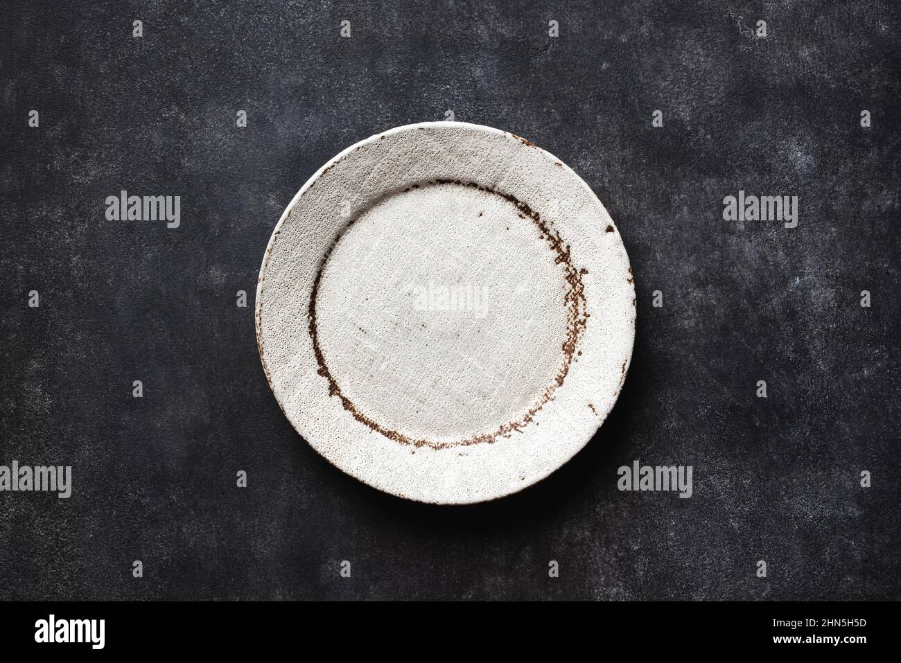 Empty Craft Ceramic Plate On Black Background. Top View Copy Space Stock Photo