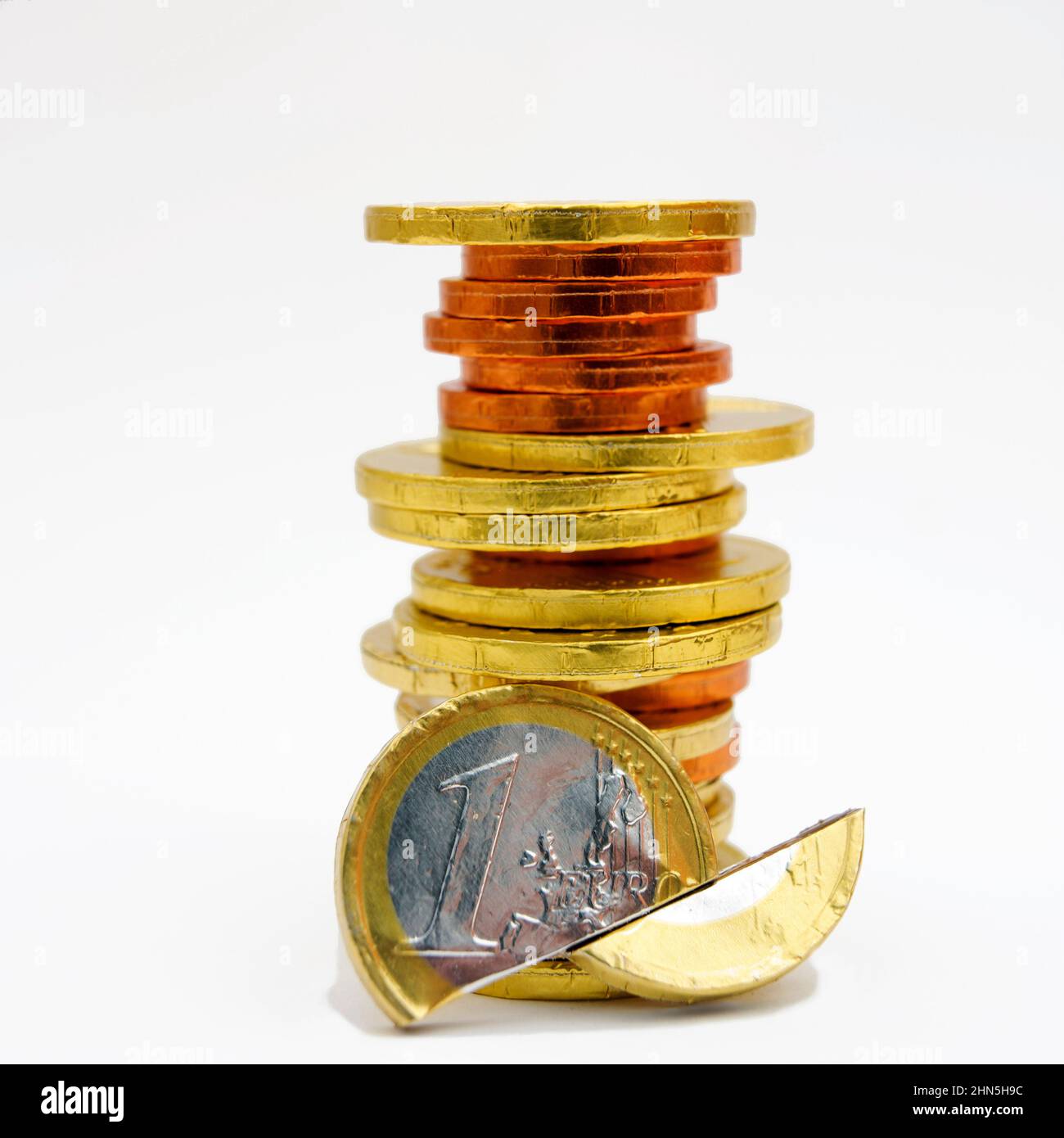 Closeup shot of chocolate euro and cent coins stacked on each other on the white background Stock Photo
