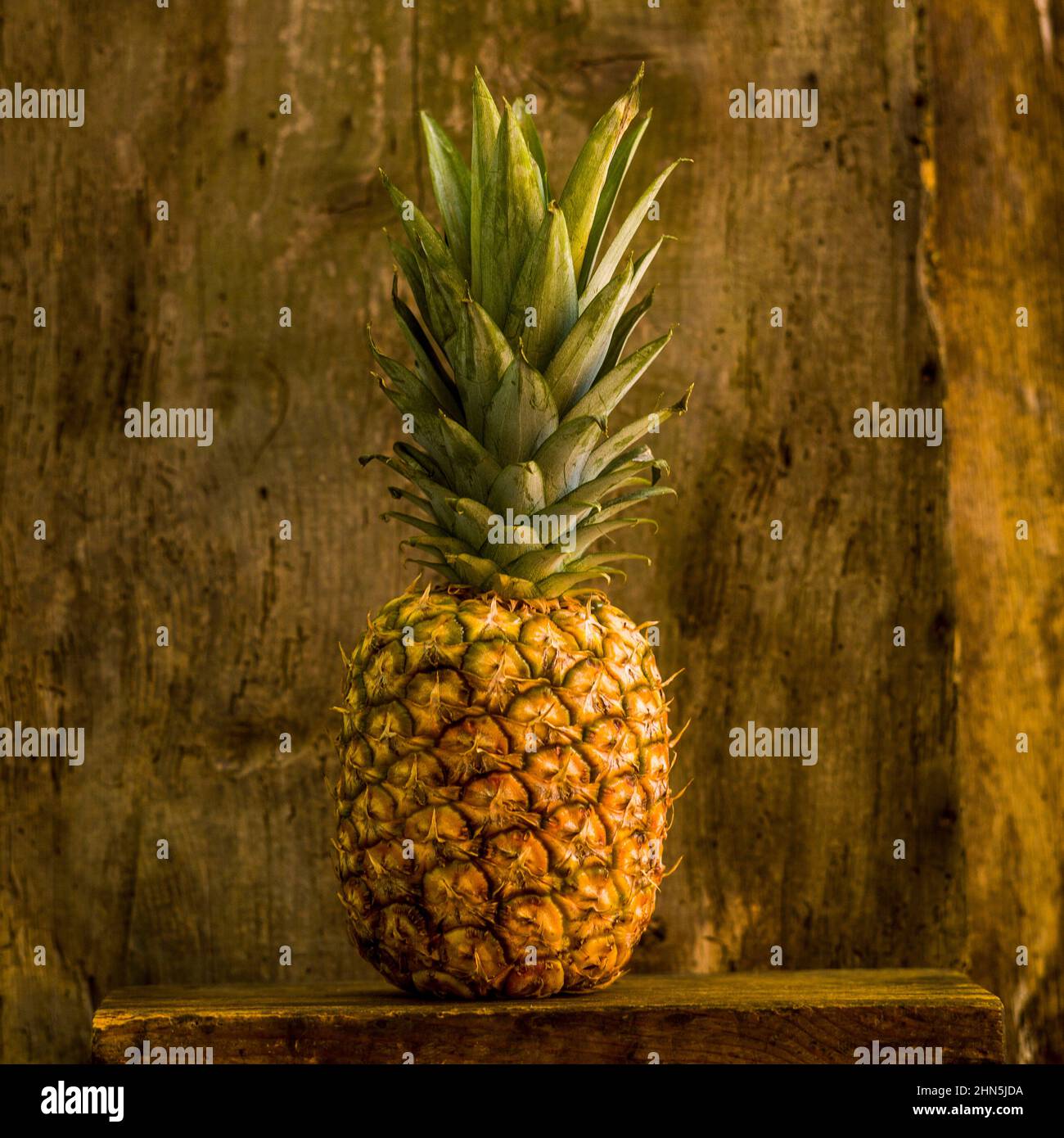 Closeup shot of fresh pineapple on a wooden surface Stock Photo