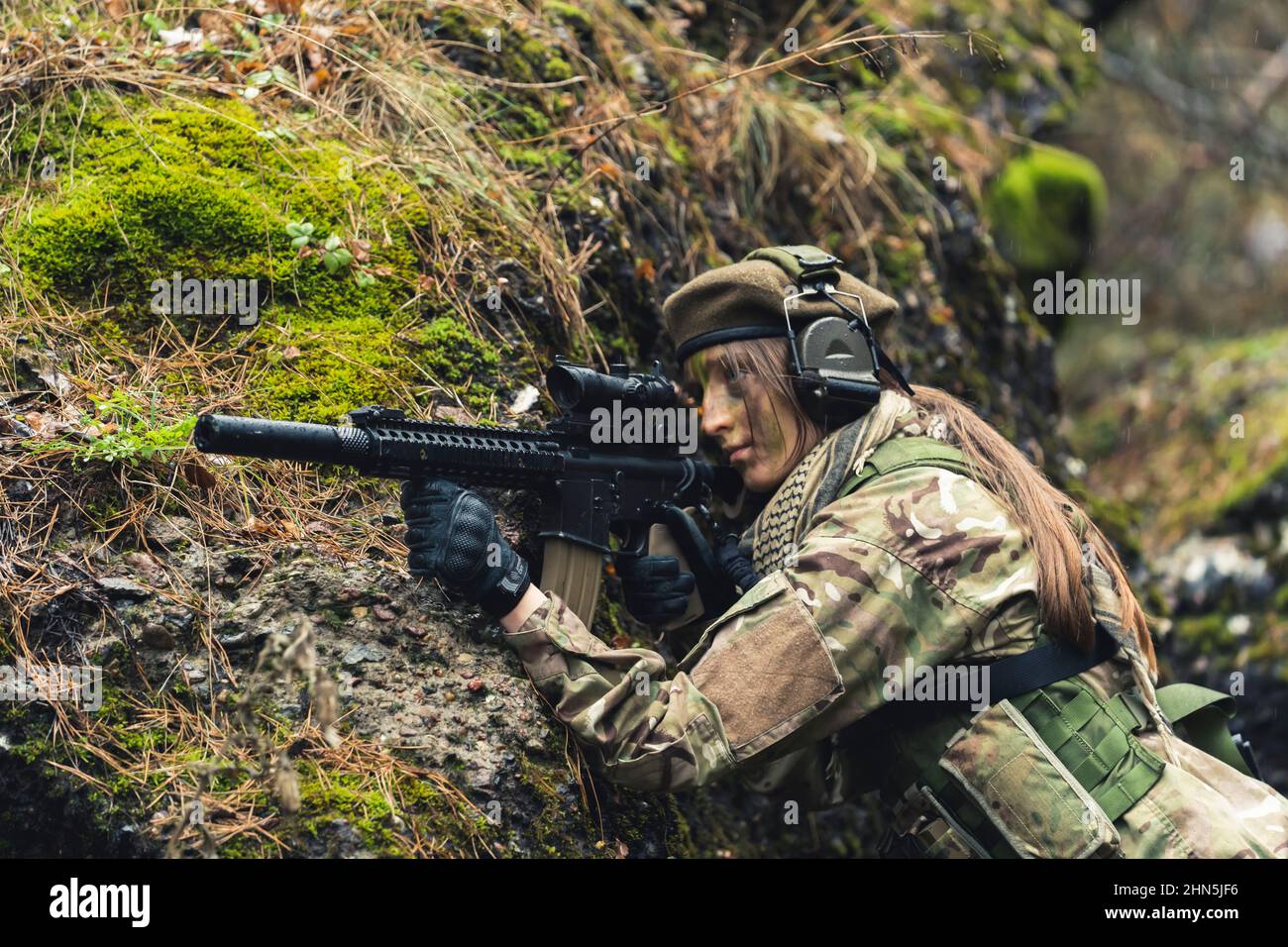 Taking cover while firing actively on ground female guard soldier . High quality photo Stock Photo