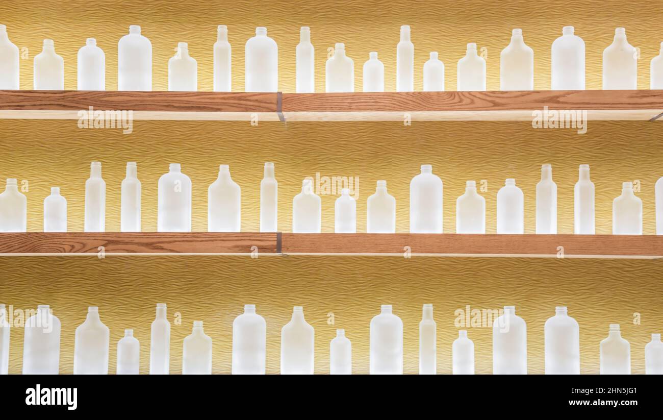Three shelves of different sized frosted bottles Stock Photo