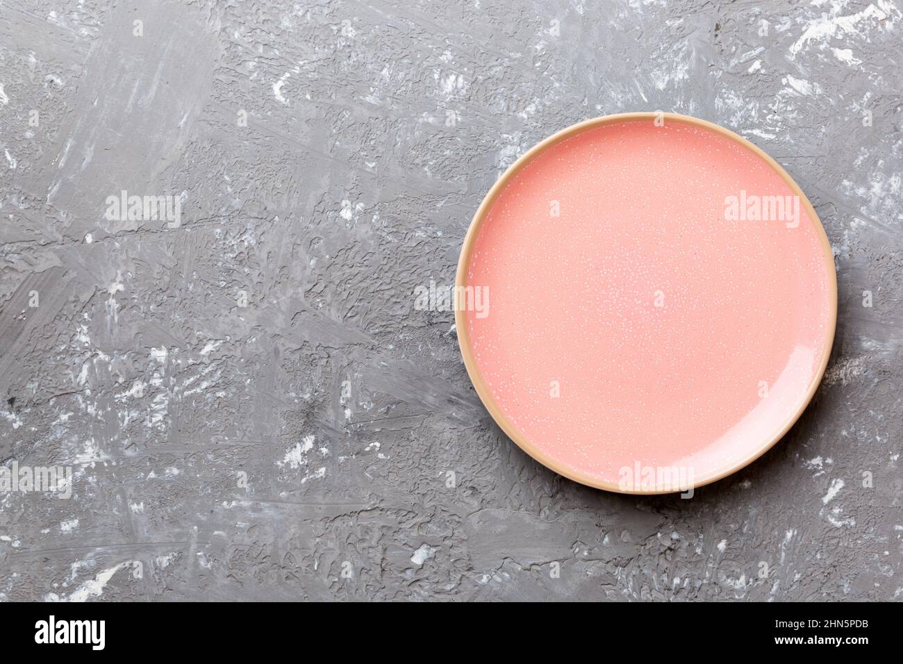 Top view of empty pink plate on cement background. Empty space for your ...