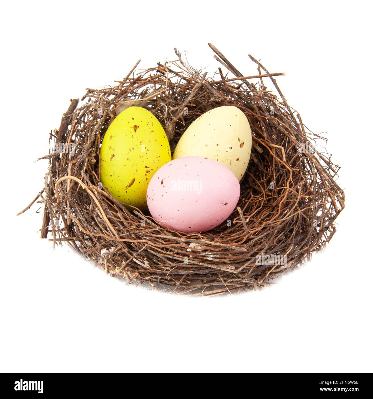 Colorful three eggs in wooden bird nest isolated on the white ...