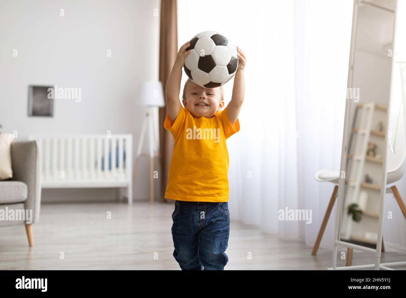 Little sportsman. Adorable little boy posing with football ball
