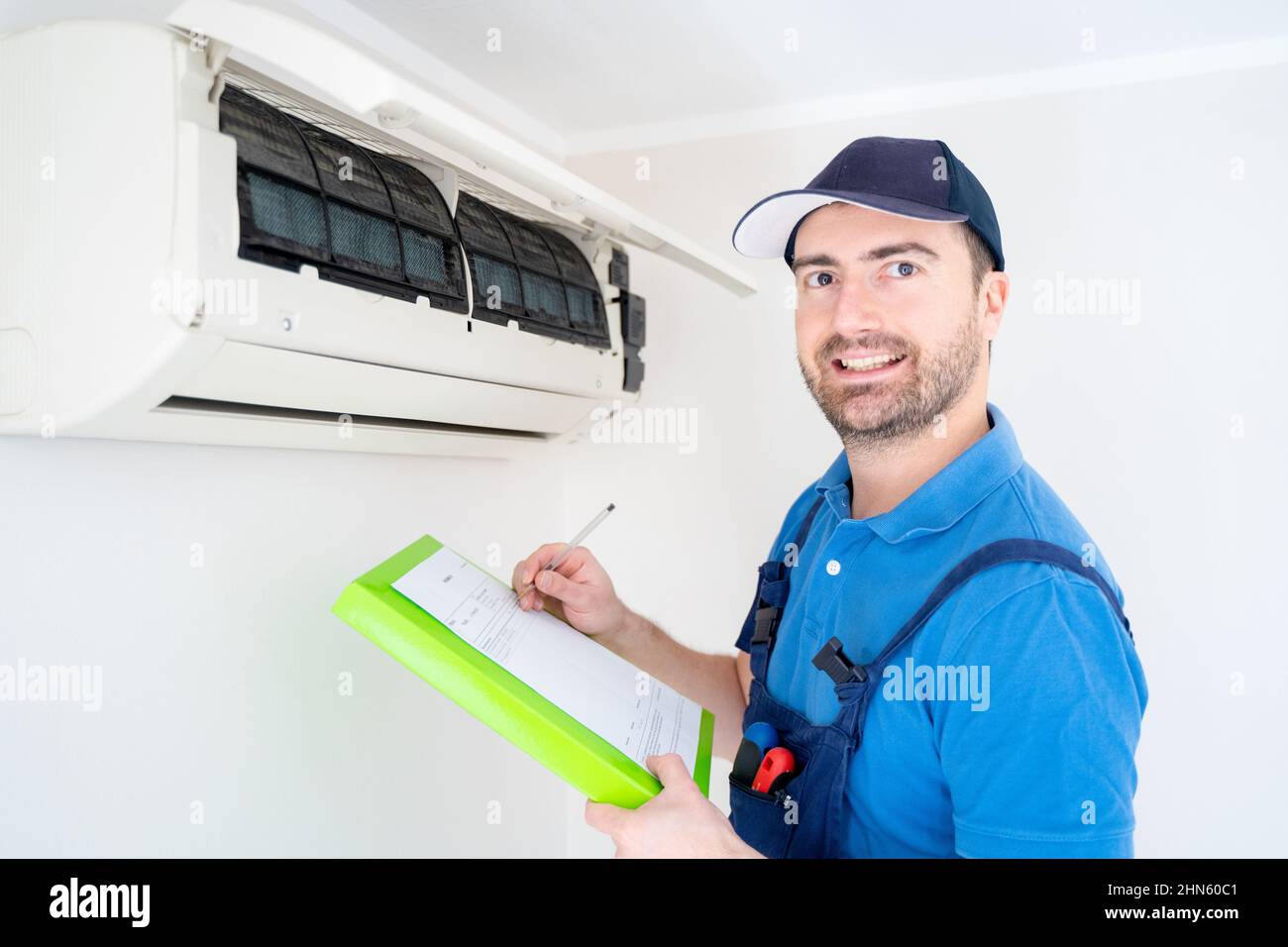 Technician with clipboard checking air conditioner for installation