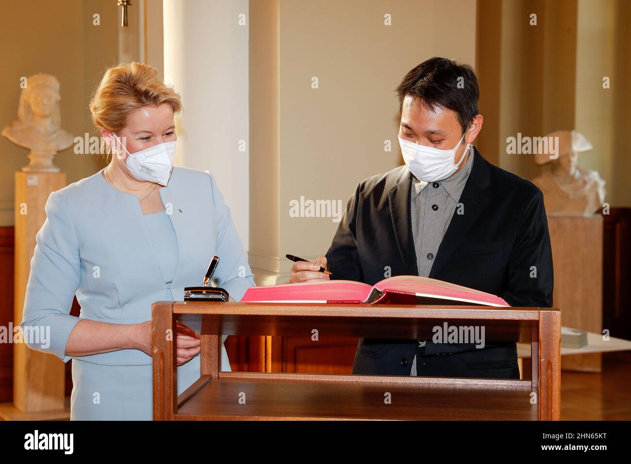 Berlin, Germany. 14th Feb, 2022. Ryusuke Hamaguchi, member of the Berlinale jury, signs the Berlin guest book in the Rotes Rathaus. On the left is Franziska Giffey, Governing Mayor of Berlin. The 72nd International Film Festival will be held in Berlin from Feb. 10-20, 2022. Credit: Gerald Matzka/dpa/Alamy Live News Stock Photo