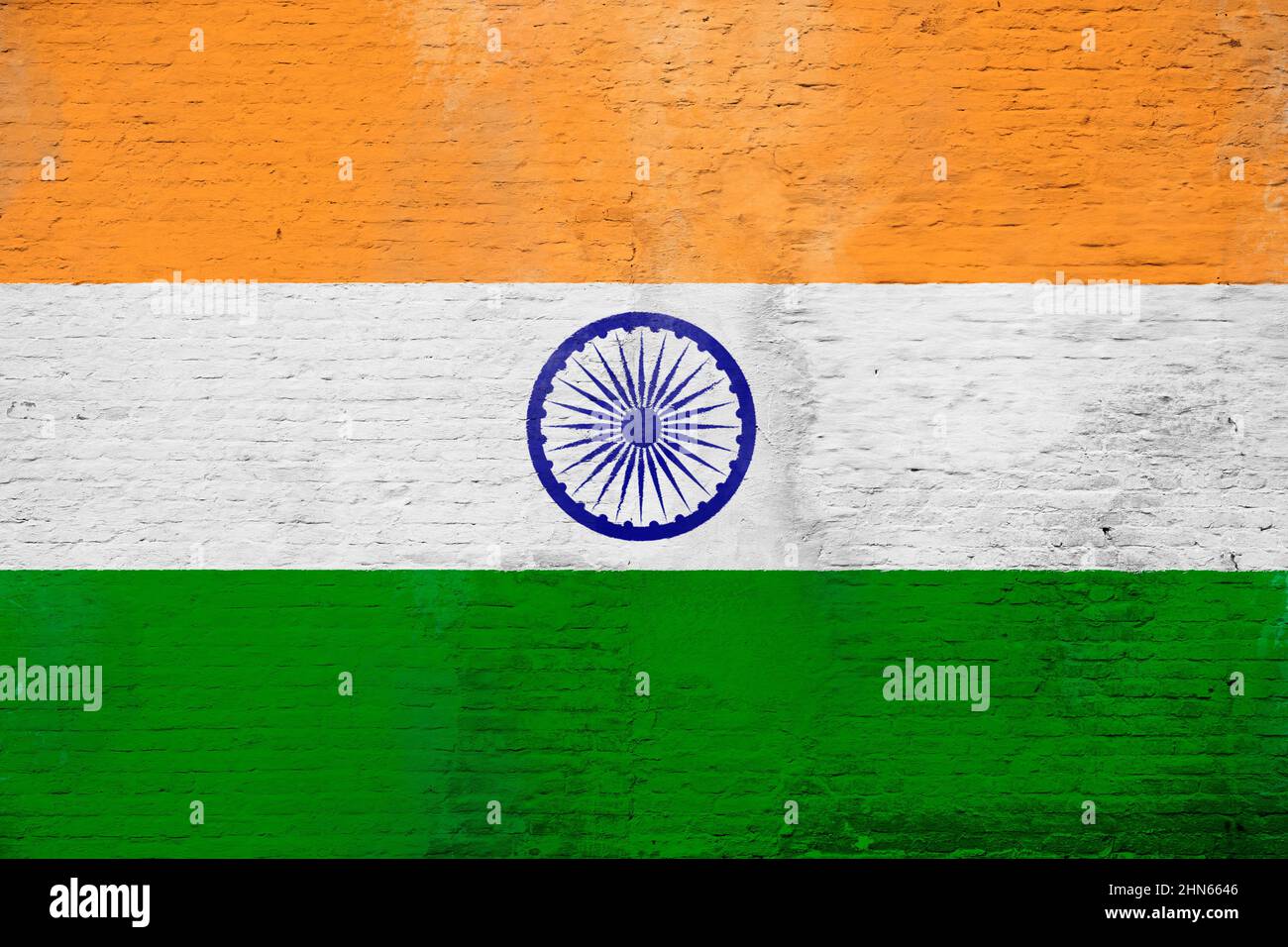 Full frame photo of a weathered flag of India painted on a plastered brick wall. Stock Photo