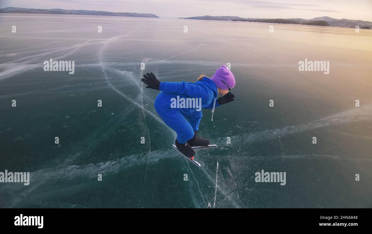 The child train on ice speed skating. The athlete at the start, in a