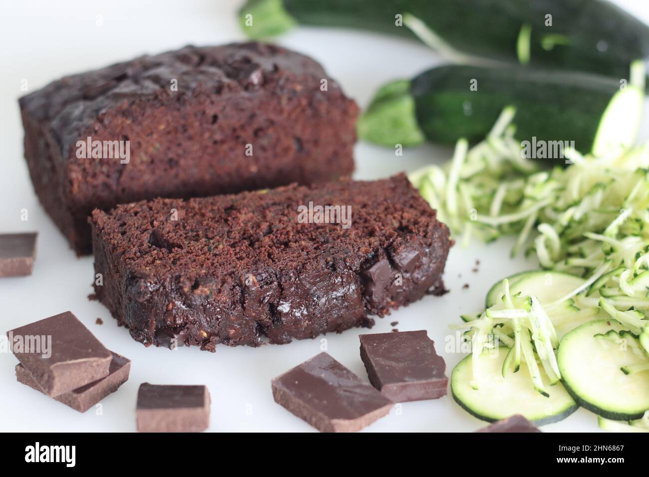Zucchini chocolate cake slices. Moist double chocolate cake with grated zucchini, coco powder, chocolate and chocolate chips. Shot on white background Stock Photo