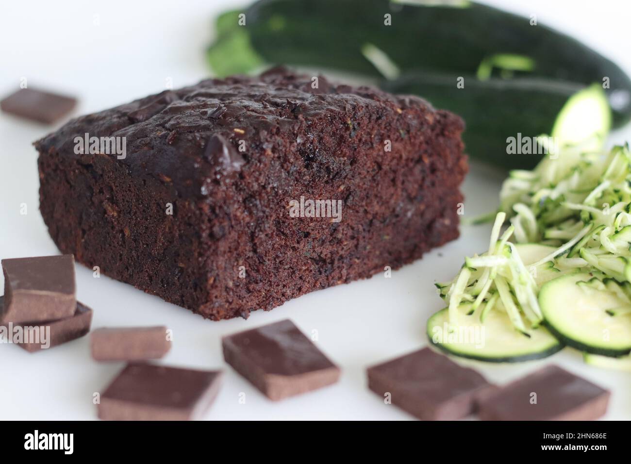 Zucchini chocolate cake. Moist double chocolate cake with grated zucchini, coco powder, chocolate and chocolate chips. Shot on white background Stock Photo
