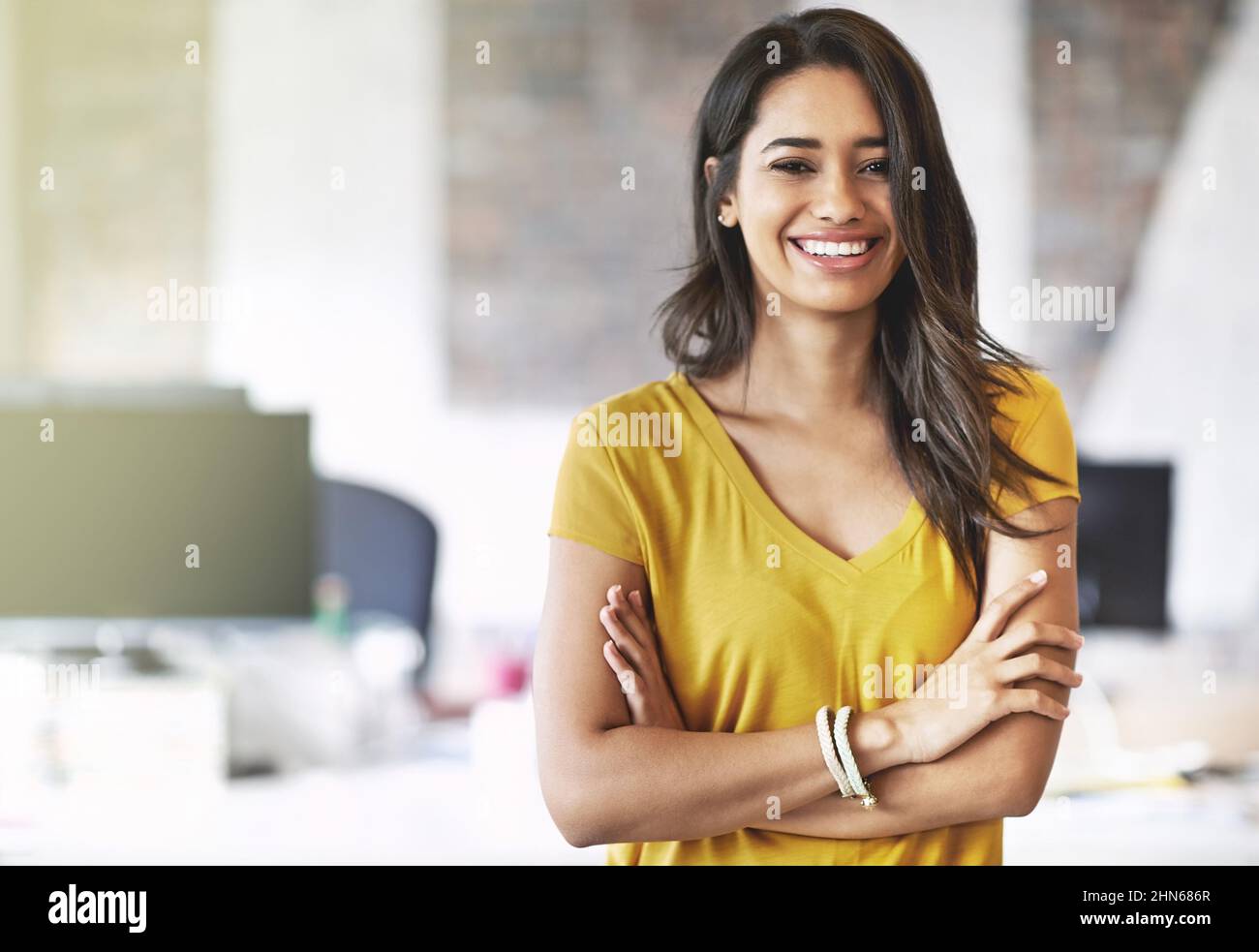 I overcome every obstacle with a smile on my face. Cropped shot of an attractive young designer standing in her office. Stock Photo