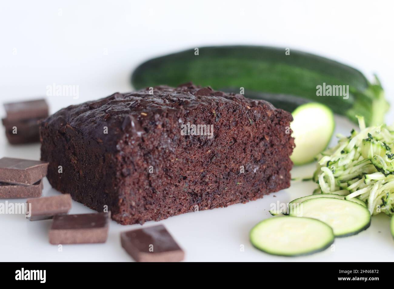Zucchini chocolate cake. Moist double chocolate cake with grated zucchini, coco powder, chocolate and chocolate chips. Shot on white background Stock Photo
