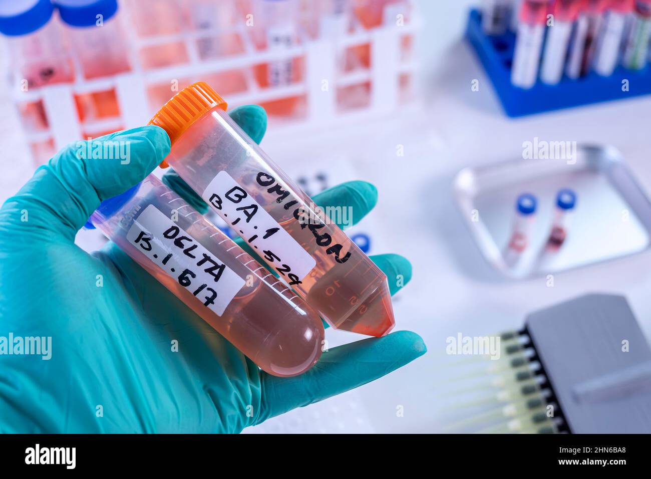 Scientist in laboratory holding vials for sars-cov2 Delta and Omicron variant research, concept image Stock Photo