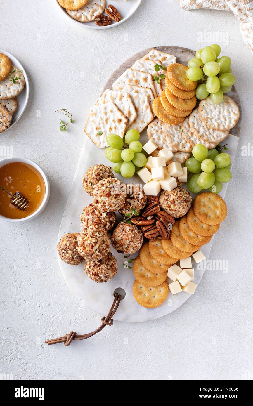 Cheese balls or truffles on a cheese board with crackers Stock Photo