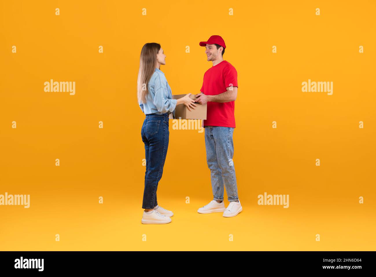 Courier Guy Giving Cardboard Parcel Boxes To Lady, Yellow Background Stock Photo Alamy