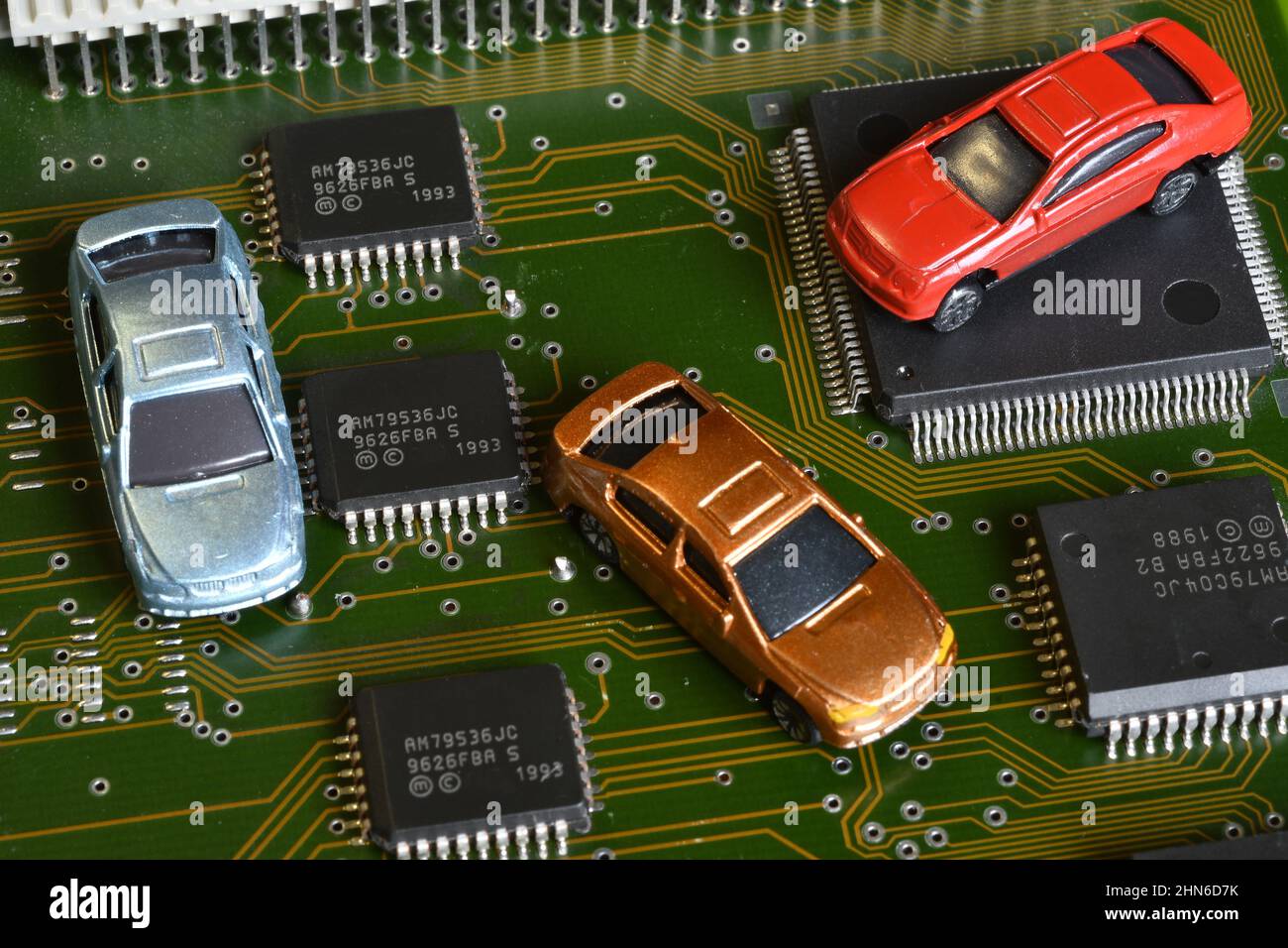 Toy cars on electronic board and microchip. The shortage of microchips