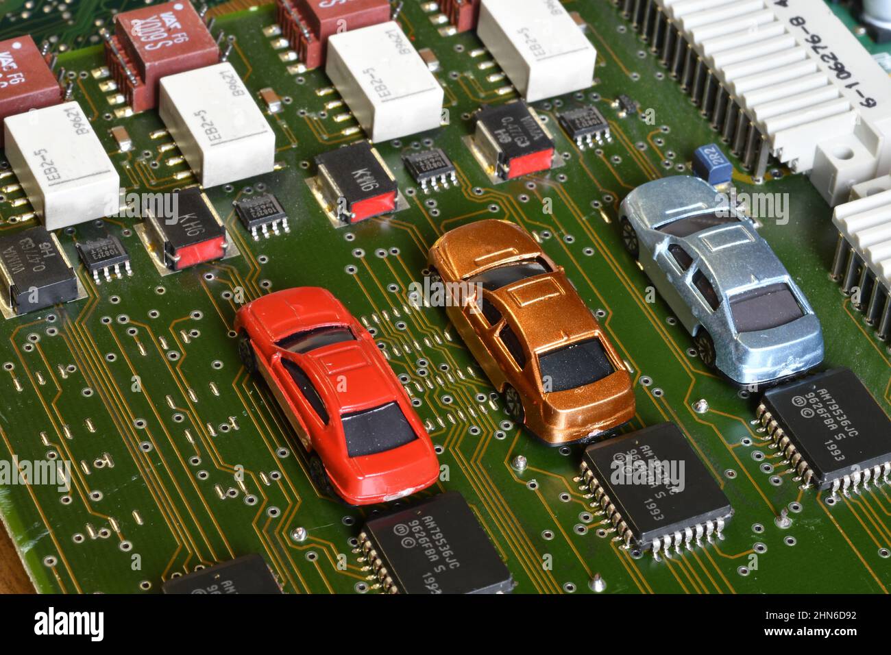 Toy cars on electronic board and microchip. The shortage of microchips