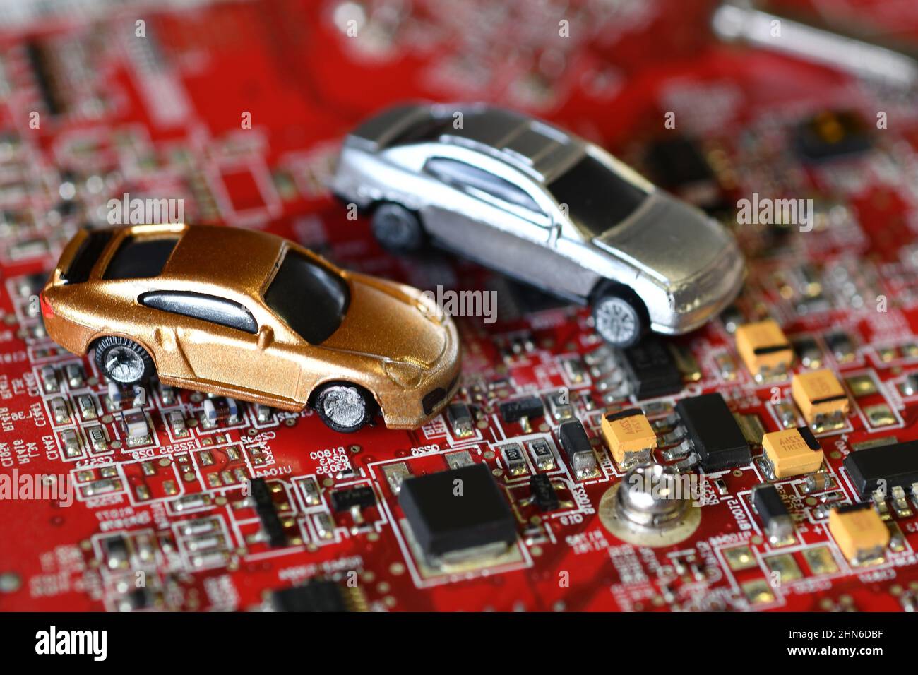 Toy cars on electronic board and microchip. The shortage of microchips