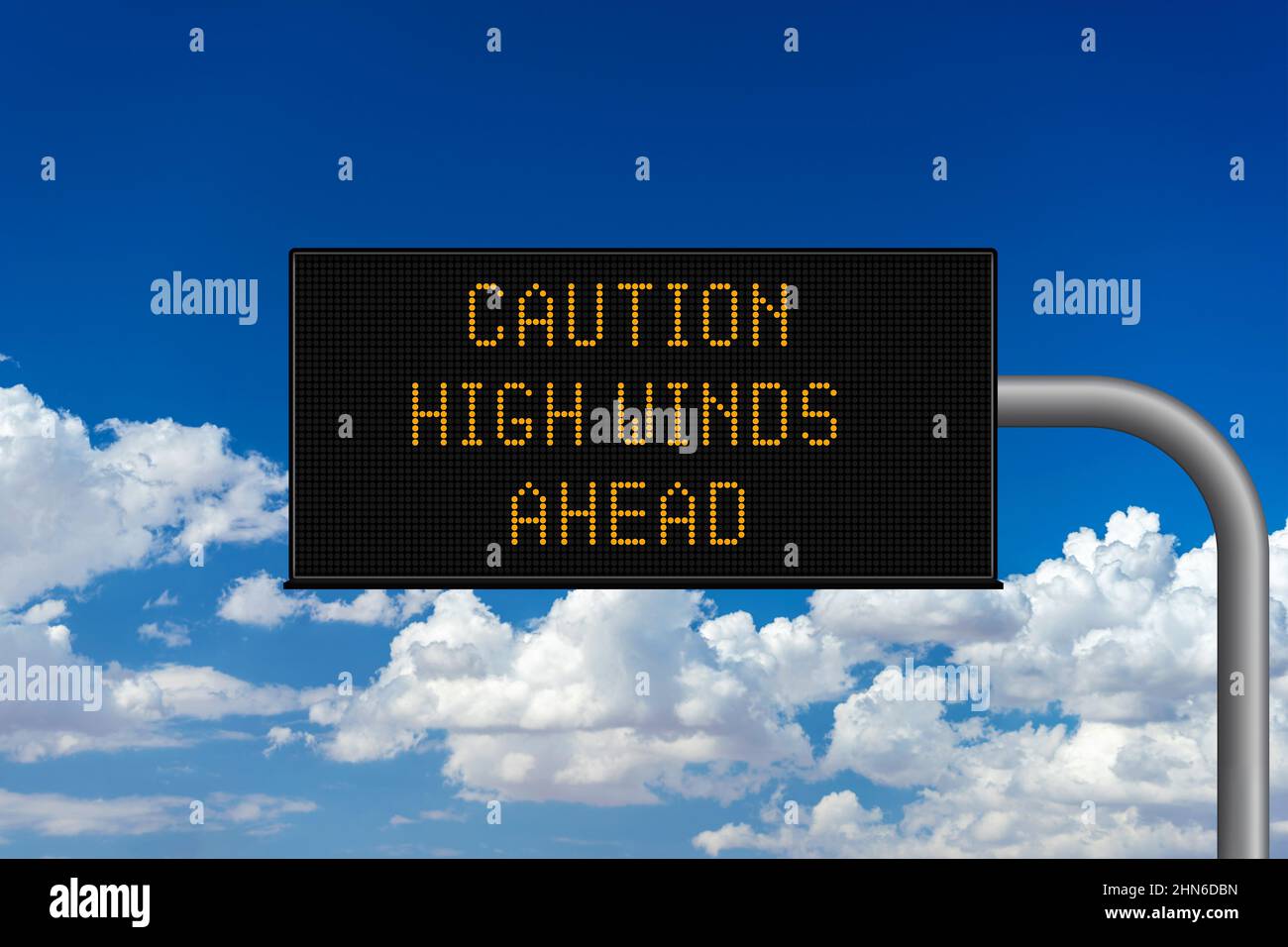 Caution High Winds Ahead variable highway sign with a cloudy sky Stock Photo