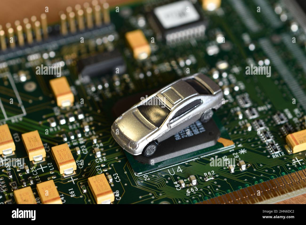 Toy cars on electronic board and microchip. The shortage of microchips
