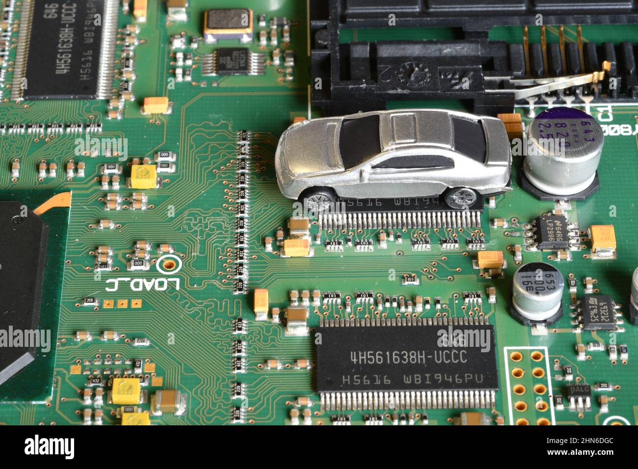 Toy cars on electronic board and microchip. The shortage of microchips