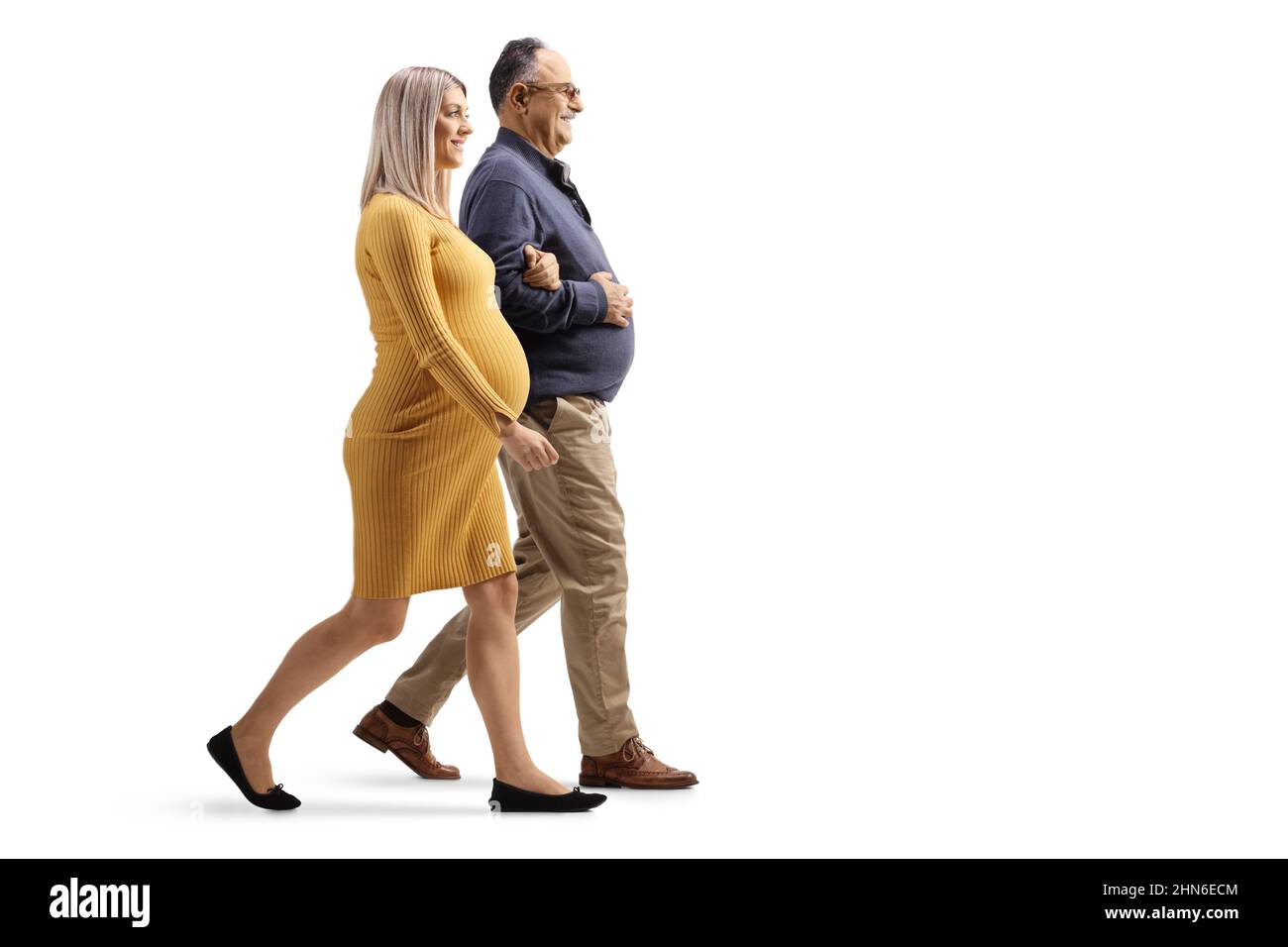 Full length profile shot of a pregnant woman walking with a mature man isolated on white background Stock Photo