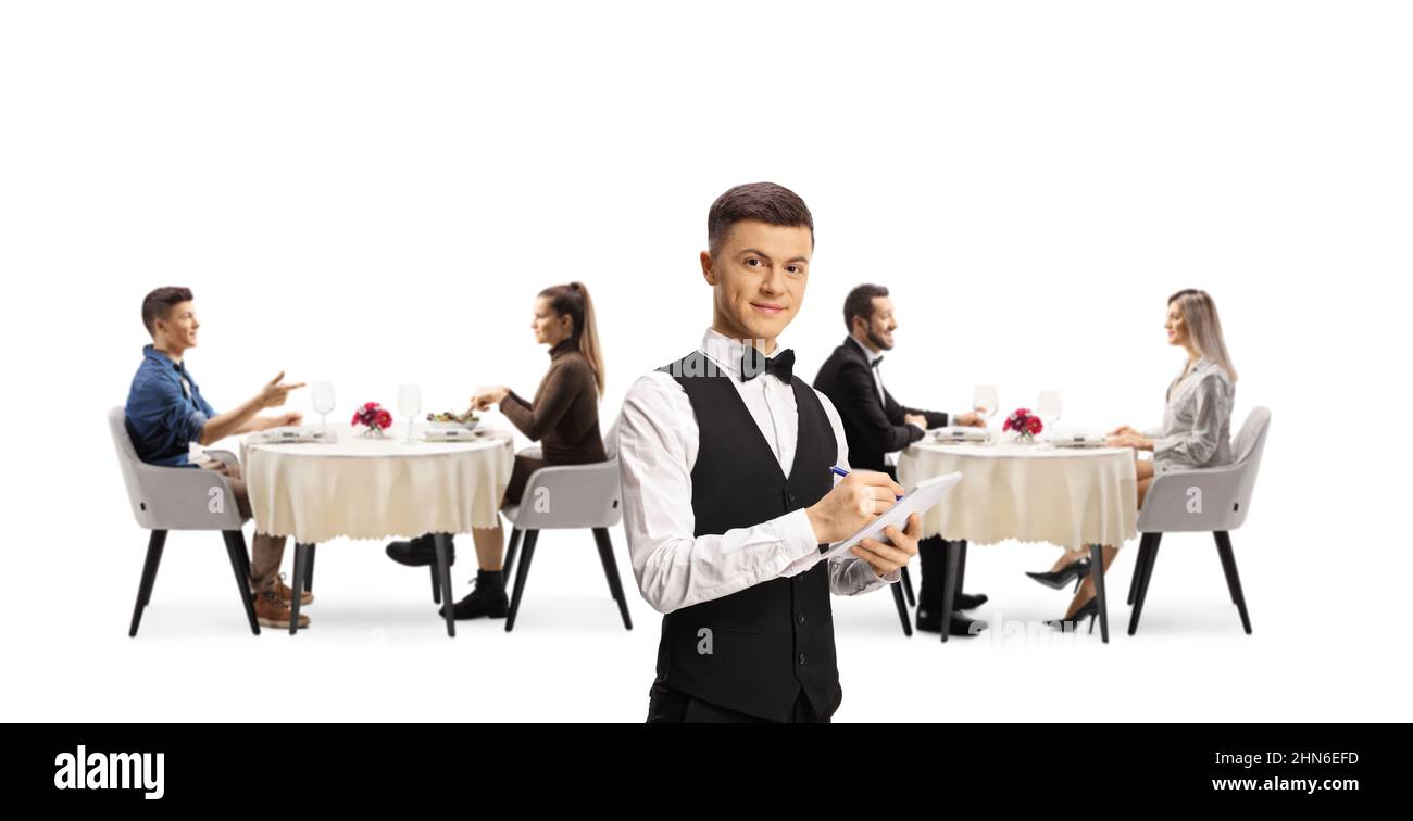 Young waiter in a restaurant and people dining in the back isolated on white background Stock Photo