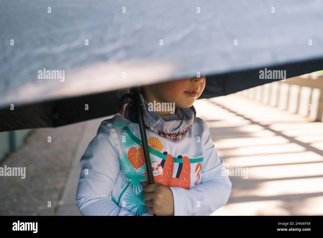Child holding an umbrella for sun protection Stock Photo