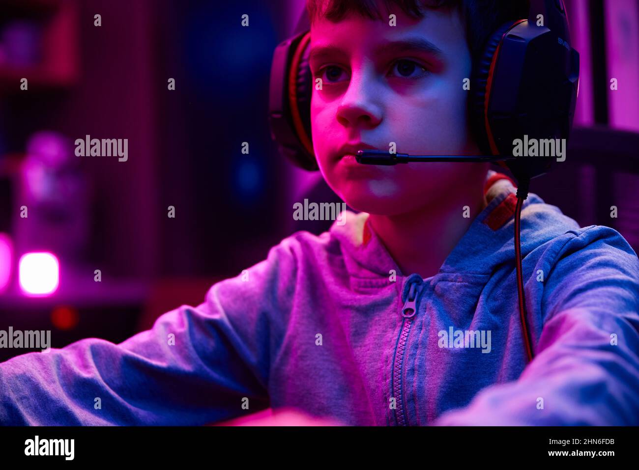 Portrait of boy playing computer video game in dark room, workplace for cybersport gaming, children gaming addiction Stock Photo
