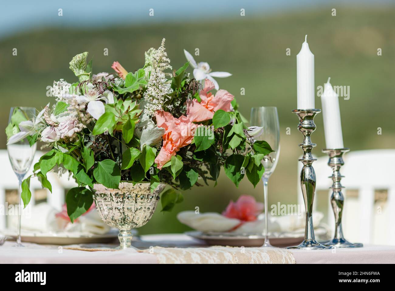 Elegant Outdoor Table Setting with Candles and Fresh Flowers Stock Photo