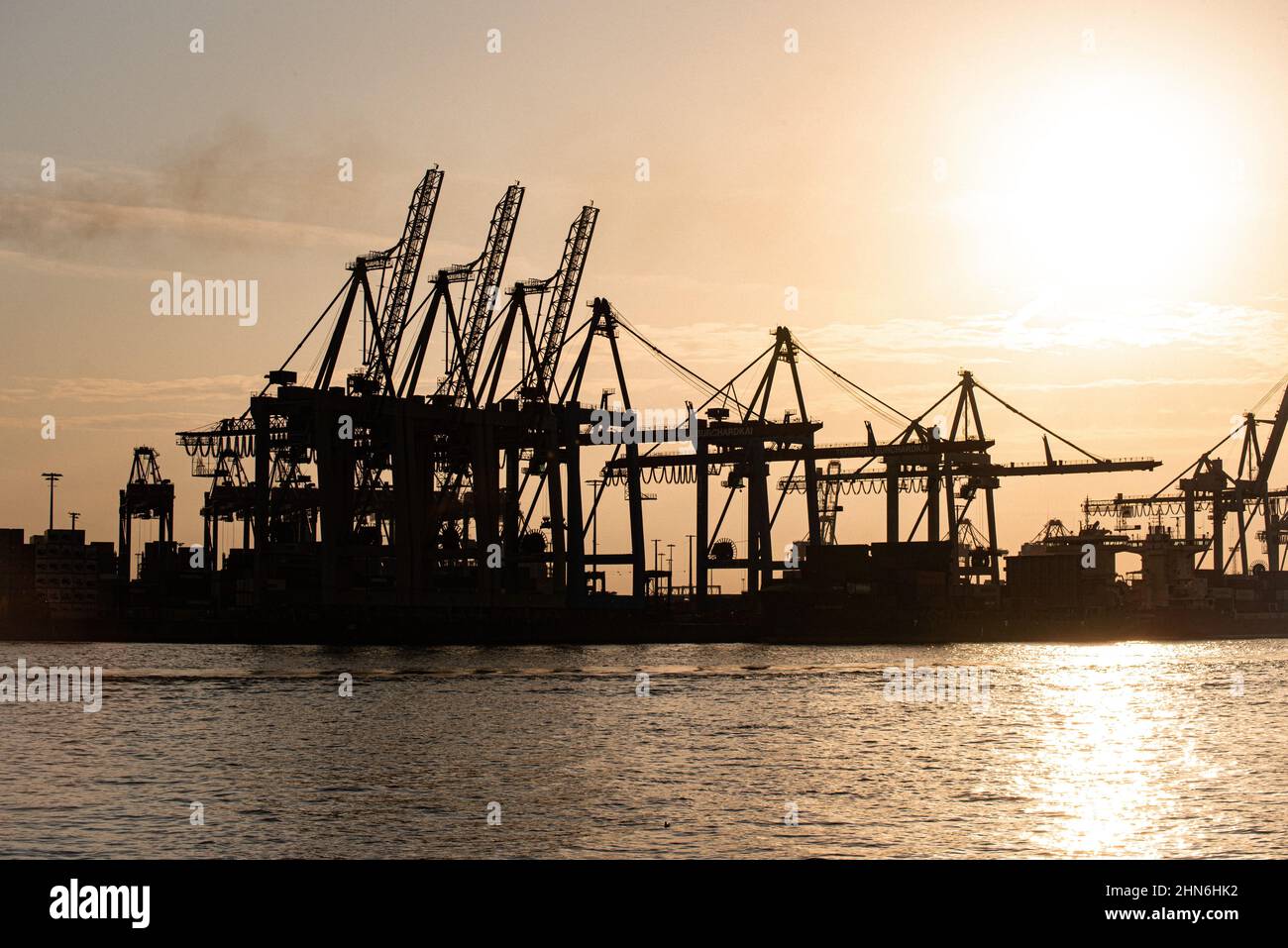 Sunset behind the loading cranes in the port of Hamburg Stock Photo