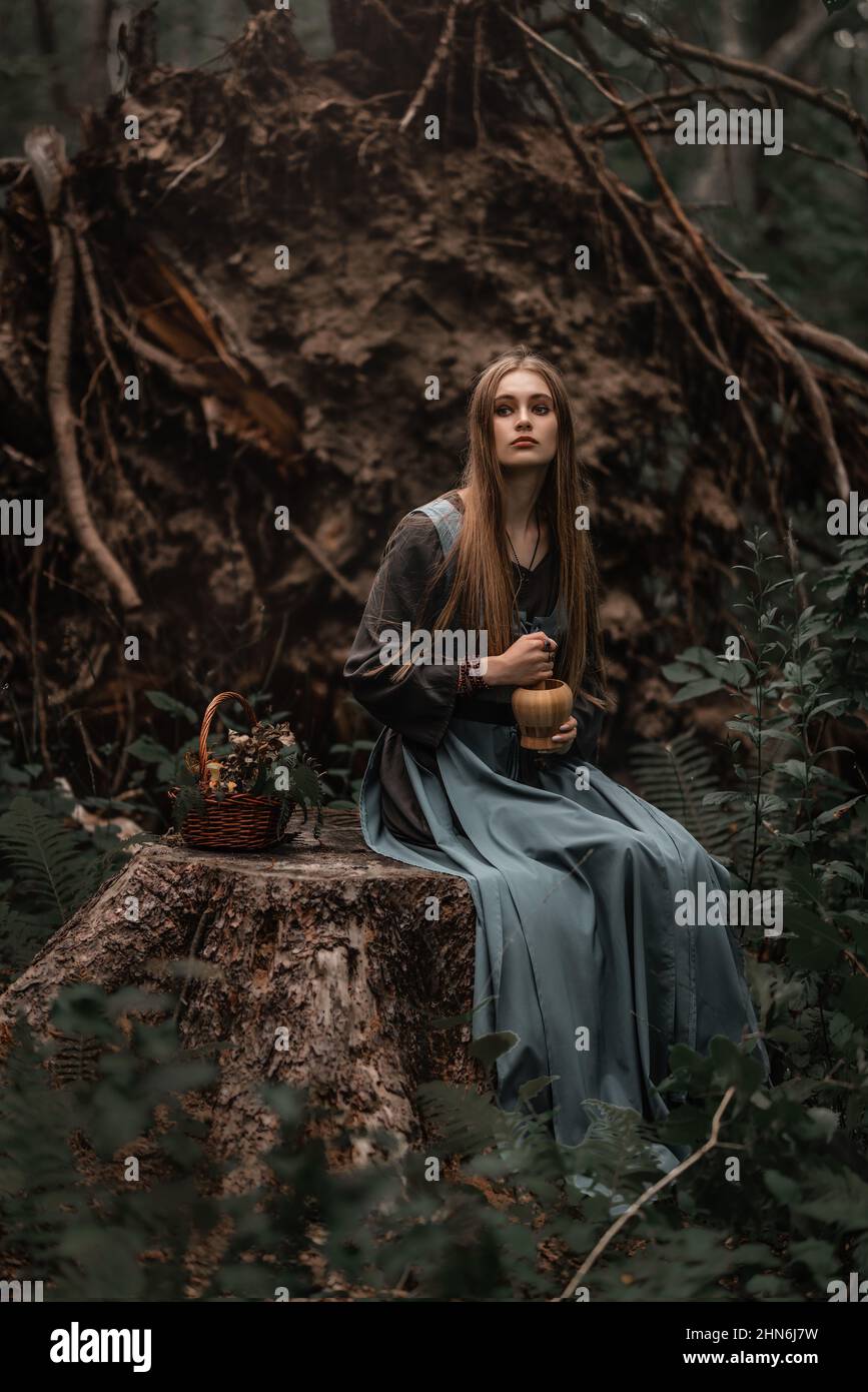 A mysterious witch walks in a dark forest Stock Photo