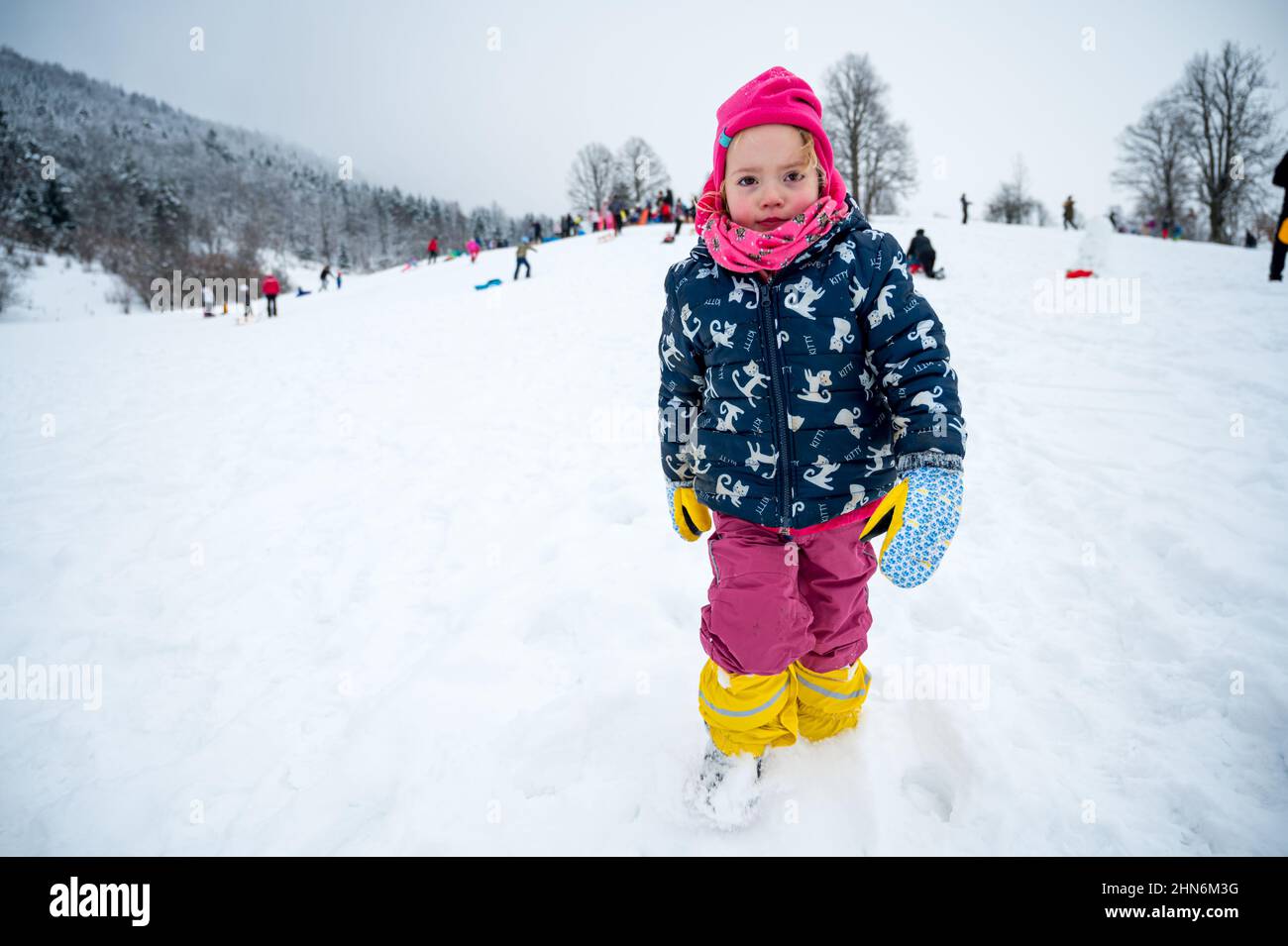 Cute girl wearing pink hat posing on snowy slope Stock Photo - Alamy