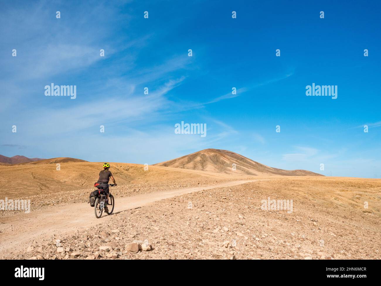 Mature female cyclist touring by bike on Fuerteventura, Canary Islands, Spain Stock Photo