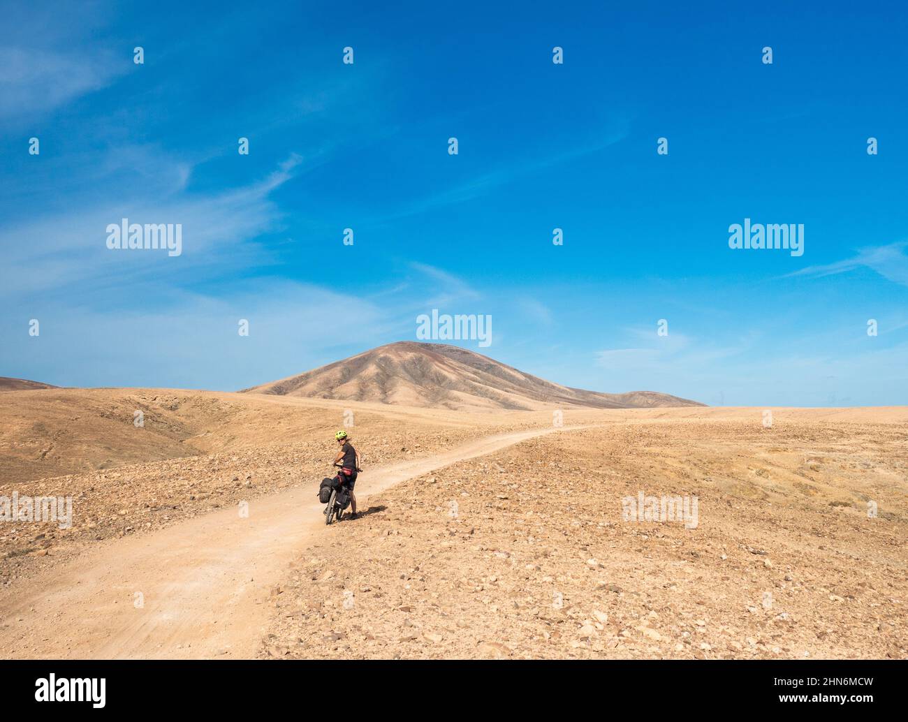 Mature female cyclist touring by bike on Fuerteventura, Canary Islands, Spain Stock Photo