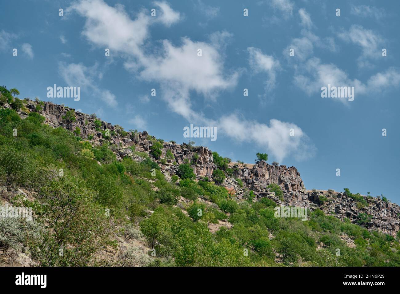 Low angle photo view of huge hill and blue sky background. Stock Photo