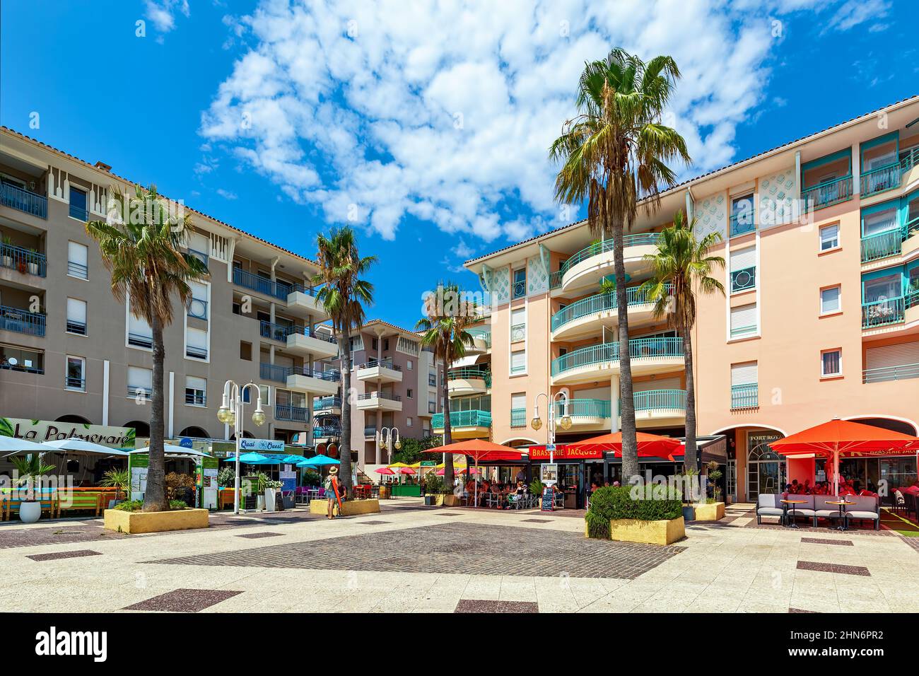 Outdoor restaurants on city square surrounded by residential buildings in Frejus - city on French Riviera. Stock Photo