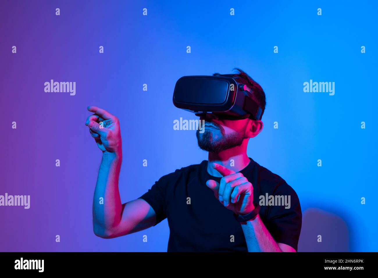 Man in virtual 3d glasses working on a project in a studio in neon