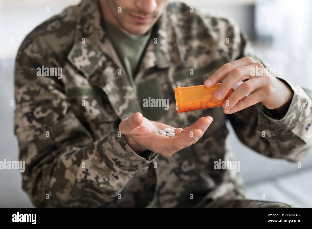 Unrecognizable man in camouflage uniform soldier taking medicine ...