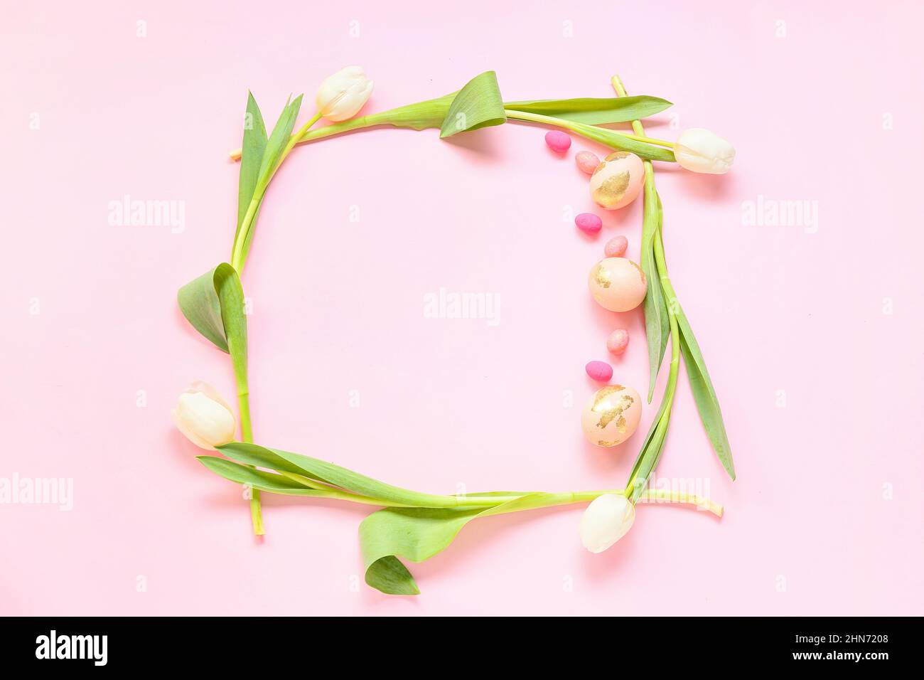Frame made of Easter eggs and flowers on pink background Stock Photo ...