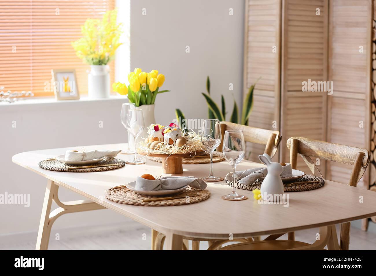 Festive dinnerware on table served for Easter celebration in room Stock Photo