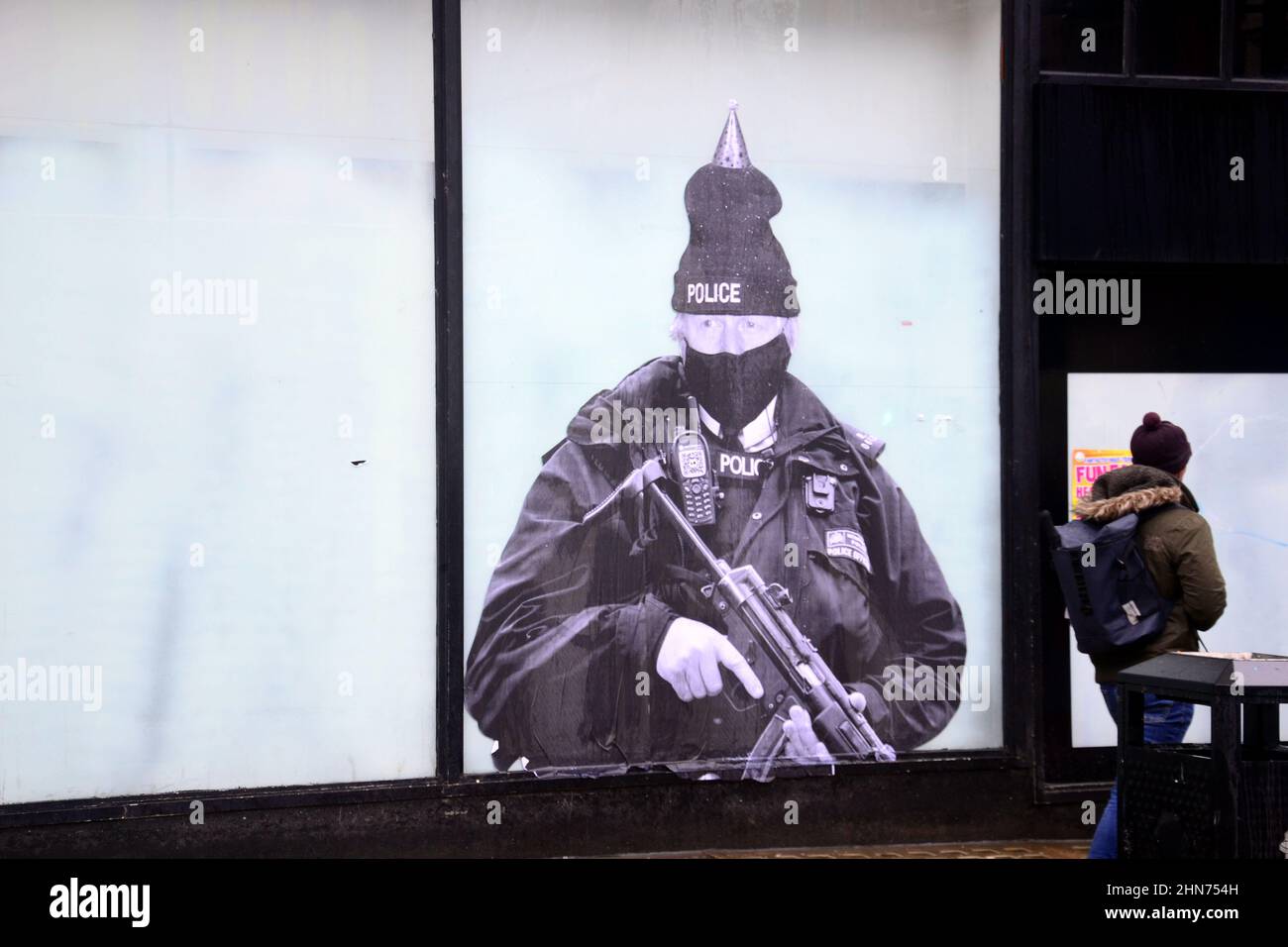 A humorous mural featuring UK Prime Minister Boris Johnson dressed as a police officer wearing a party hat has appeared in central Manchester, UK. Stock Photo