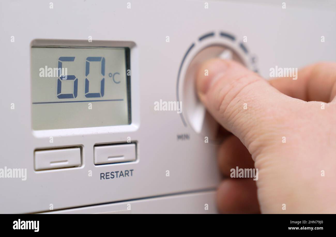 EMABRGOED TO 2200 MONDAY FEBRUARY 14 File photo dated 03/02/22/ of a homeowner turning down the temperature of a gas boiler in Basingstoke, Hampshire. People in Wales are to get extra help in the face of the cost-of-living crisis, with politicians in the devolved nation saying they are going 'above and beyond' as they criticised the Chancellor whose offer they said 'fell short' of what was needed. Wales' minister for finance and local government, Rebecca Evans, said the government is 'more than doubling the equivalent support provided by the UK Government' for those most in need, as it aims to Stock Photo