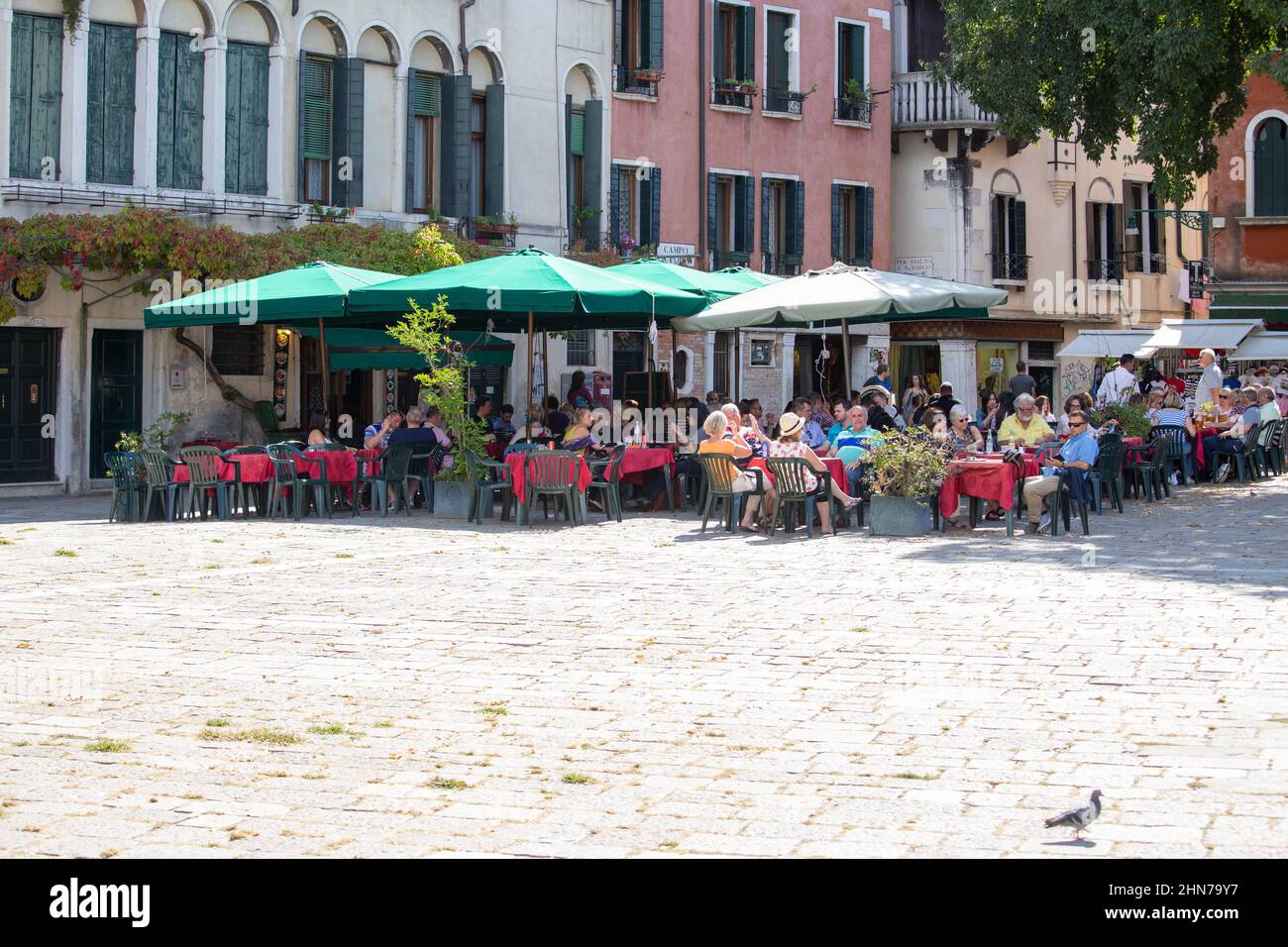 tourists in one of the many cafes and restaurants located on the venetian streets Stock Photo
