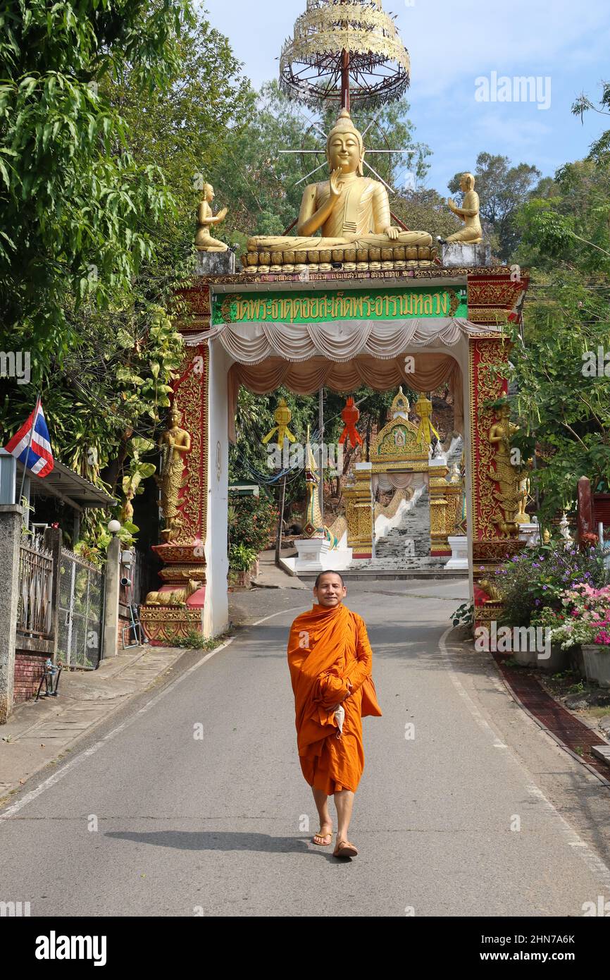 Smiling monk walking at entrance to Wat Phra That, Doi Saket, Chiang Mai, Thailand Stock Photo