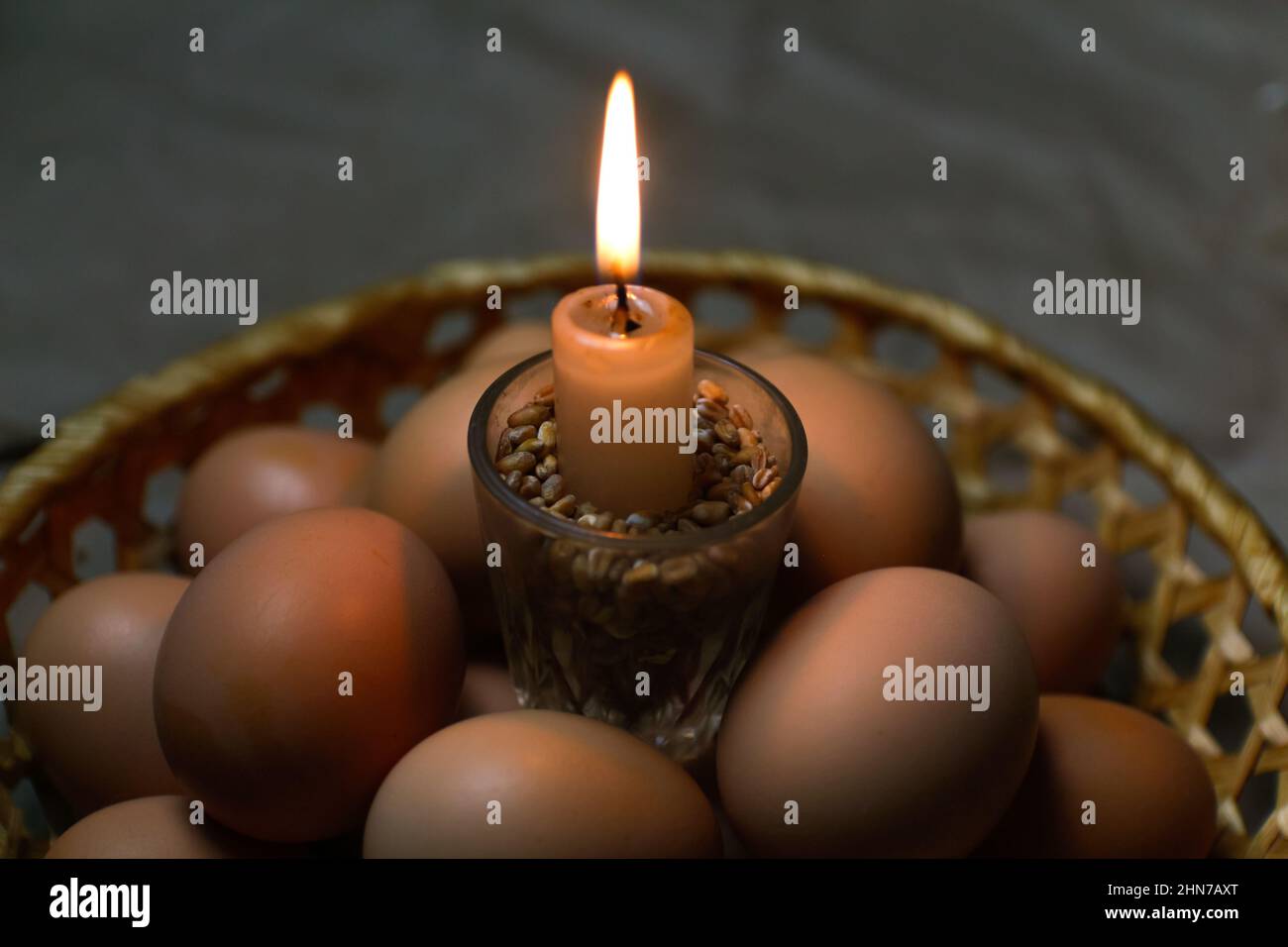 Candle with light. Rustic background. Paschal eggs, Pysankas