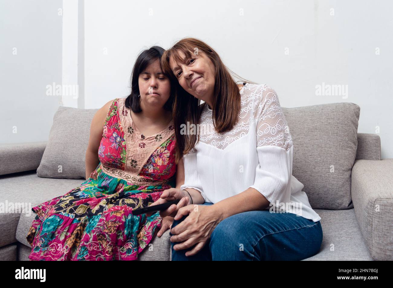 Caucasian Hispanic Latina Mom And Daughter Together Sitting On A Sofa Inside The House With